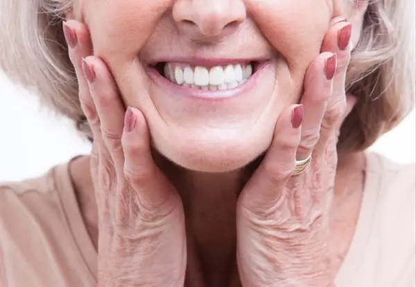 Elderly woman's smile sparkles after dental care