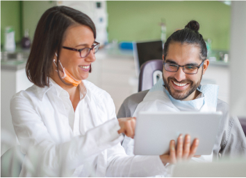 Dentist showing laptop of results to patient