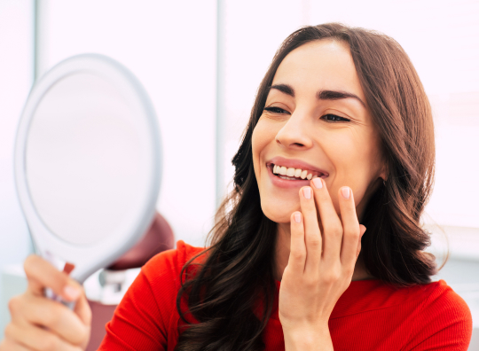 woman looking at teeth in mirror