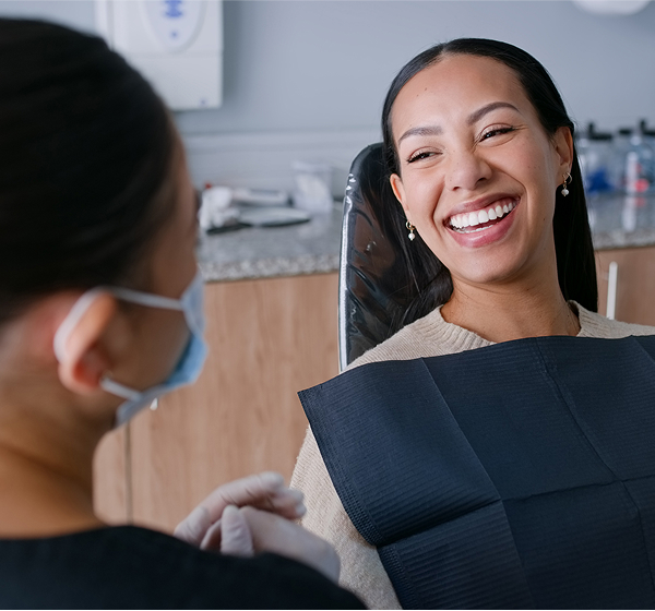 woman in dentist chair smiling at dentist