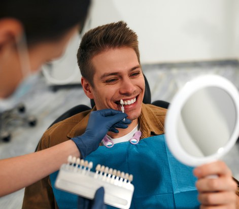 man checking his smile with a mirror