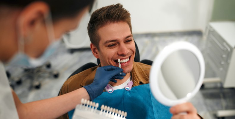 man checking his smile with a mirror